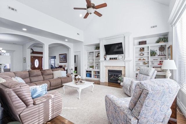 1303 NW Hermanus St, Bentonville, AR 72712 - living room featuring visible vents, ceiling fan with notable chandelier, wood finished floors, and high vaulted ceiling