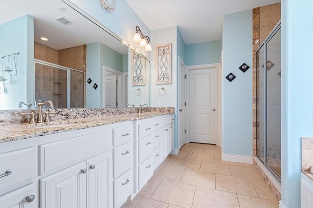 1303 NW Hermanus St, Bentonville, AR 72712 - bathroom featuring visible vents, tile patterned flooring, double vanity, a sink, and a stall shower
