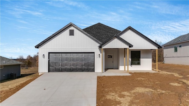 modern farmhouse featuring a garage and central air condition unit