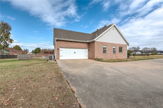 view of property exterior featuring central AC unit, a garage, and a yard