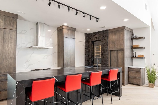 514 N Vinson Ave, Fayetteville, AR 72701 - kitchen with wall chimney range hood, a kitchen breakfast bar, open shelves, a sink, and recessed lighting