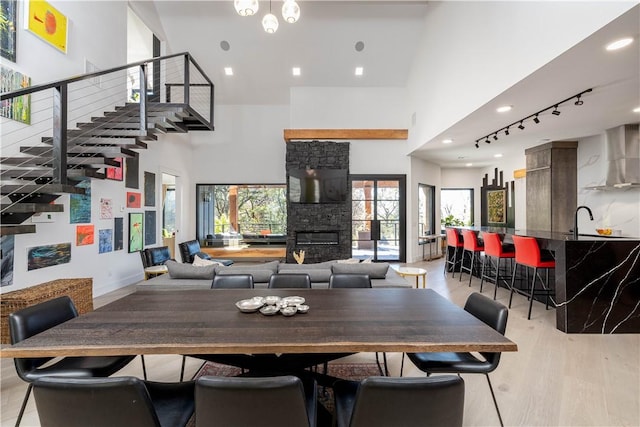 514 N Vinson Ave, Fayetteville, AR 72701 - dining room featuring a towering ceiling, a fireplace, light wood-type flooring, track lighting, and recessed lighting
