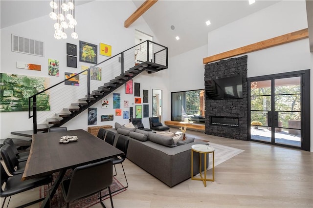 514 N Vinson Ave, Fayetteville, AR 72701 - living room featuring high vaulted ceiling, stairway, light wood-type flooring, a fireplace, and beamed ceiling