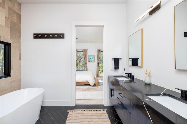 514 N Vinson Ave, Fayetteville, AR 72701 - ensuite bathroom featuring tile patterned floors, a soaking tub, double vanity, and baseboards