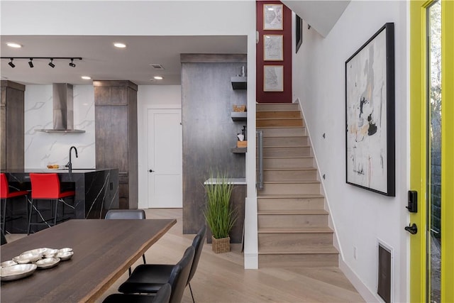514 N Vinson Ave, Fayetteville, AR 72701 - dining space featuring stairs, recessed lighting, light wood-style floors, baseboards, and wet bar