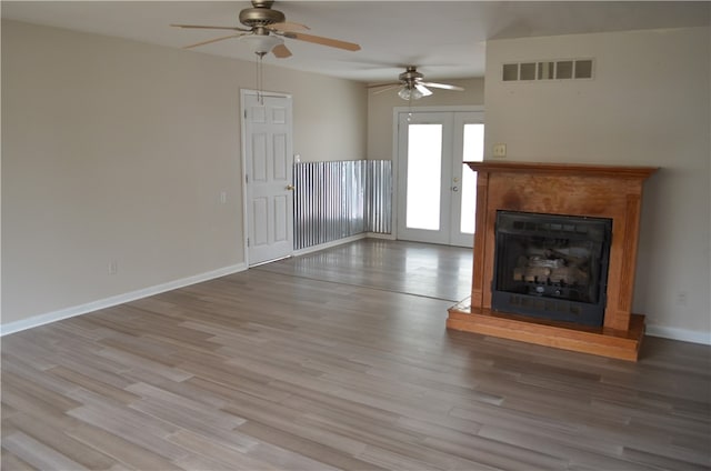 unfurnished living room featuring ceiling fan, light wood-type flooring, and french doors