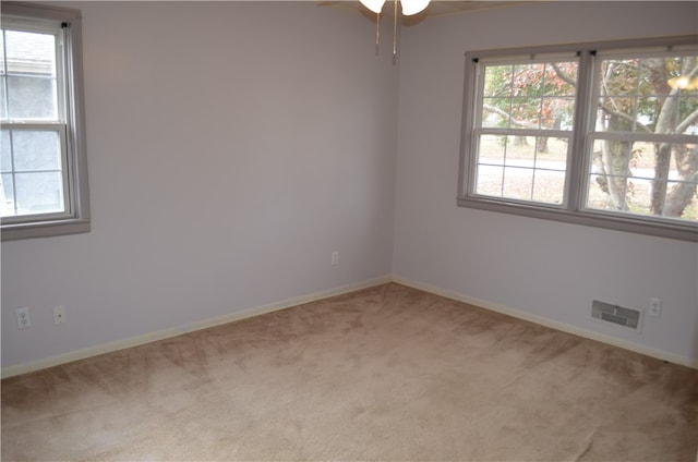 carpeted spare room featuring ceiling fan