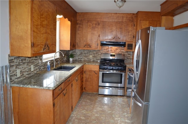 kitchen featuring ventilation hood, stainless steel appliances, backsplash, light stone countertops, and sink