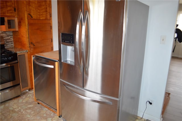 kitchen featuring tasteful backsplash, light stone countertops, and stainless steel appliances