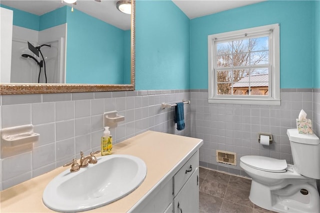 full bath featuring tile patterned floors, vanity, tile walls, toilet, and visible vents