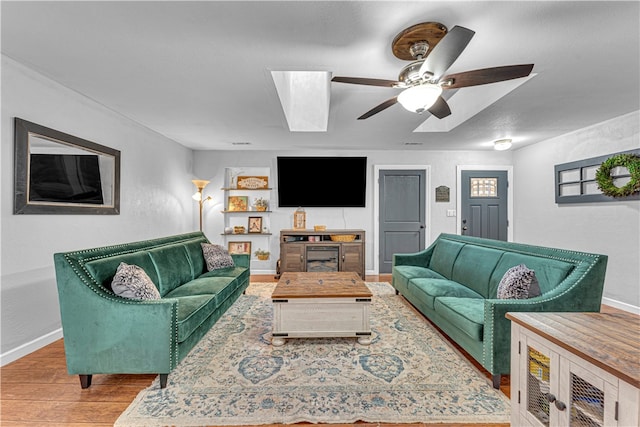 living room with ceiling fan and light hardwood / wood-style flooring