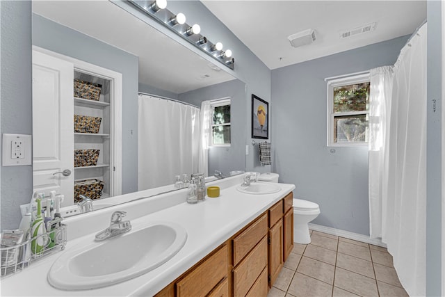 bathroom featuring tile patterned floors, vanity, toilet, and a wealth of natural light