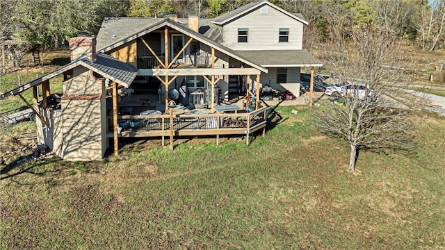 back of house featuring a lawn, a balcony, and a wooden deck