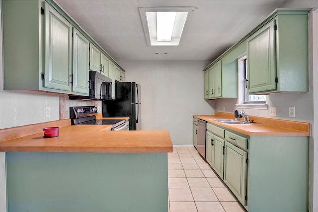 kitchen with kitchen peninsula, appliances with stainless steel finishes, green cabinets, and light tile patterned floors