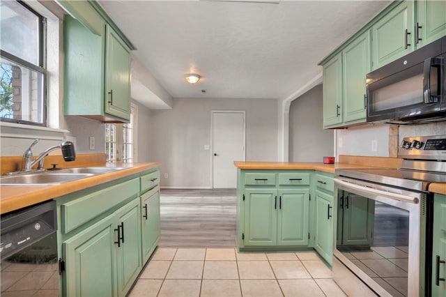 kitchen featuring a healthy amount of sunlight, sink, black appliances, and green cabinetry