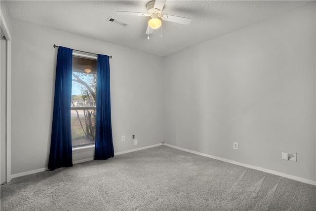 carpeted empty room featuring a textured ceiling and ceiling fan