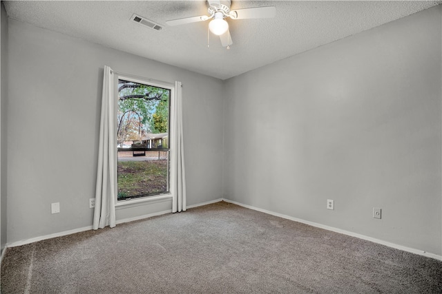 spare room with a textured ceiling, carpet floors, and ceiling fan