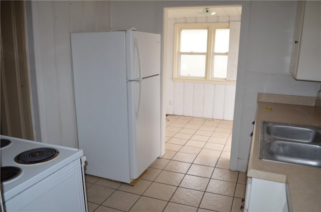 kitchen featuring white cabinets, white appliances, sink, and light tile patterned flooring