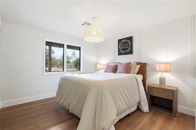 bedroom with dark hardwood / wood-style flooring