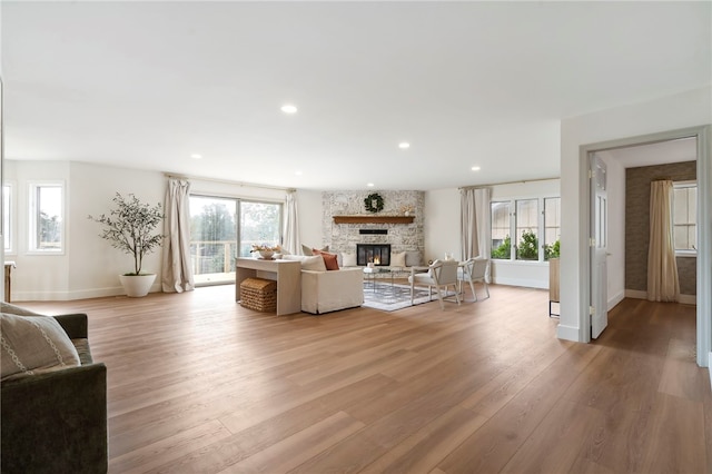 living room with a wealth of natural light, a fireplace, and light hardwood / wood-style floors