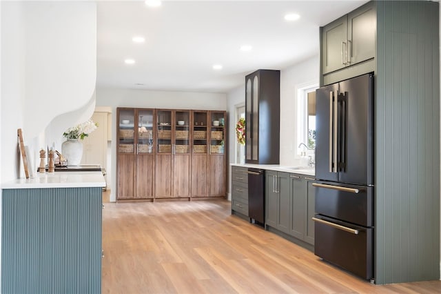 kitchen featuring sink, high end fridge, and light hardwood / wood-style flooring