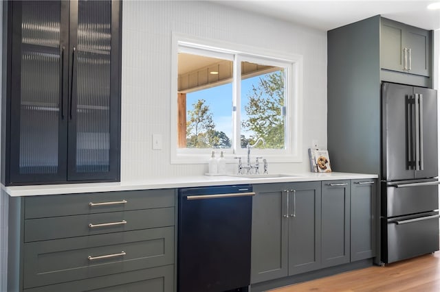 bar featuring gray cabinetry, sink, black dishwasher, light hardwood / wood-style flooring, and high quality fridge