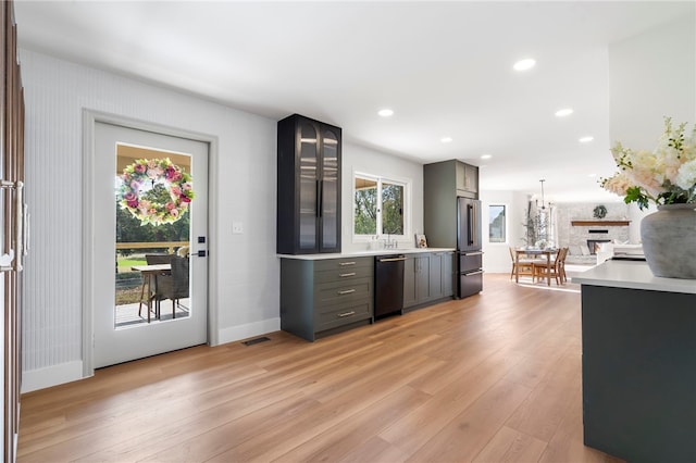 kitchen featuring stainless steel appliances, light hardwood / wood-style flooring, hanging light fixtures, and gray cabinetry