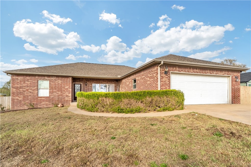 ranch-style house with a garage and a front yard