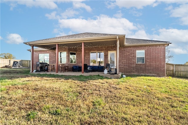 rear view of property featuring a lawn, a patio, an outdoor hangout area, and ceiling fan