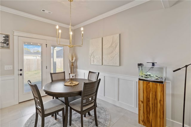 tiled dining area featuring ornamental molding and a notable chandelier