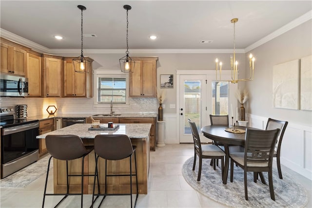 kitchen featuring light stone countertops, appliances with stainless steel finishes, and crown molding