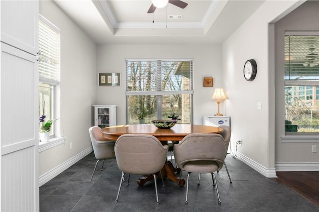 dining area with a tray ceiling, ceiling fan, a healthy amount of sunlight, and ornamental molding