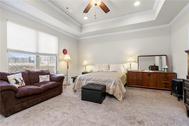 carpeted bedroom with a raised ceiling, ceiling fan, and ornamental molding