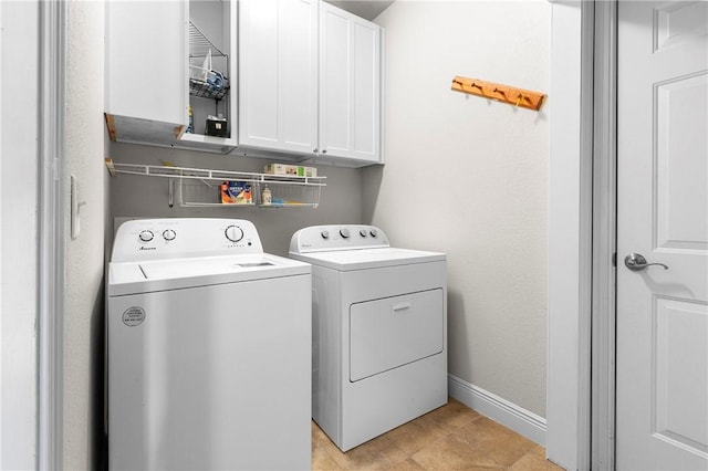 laundry room with cabinets, washer and clothes dryer, and light tile patterned flooring