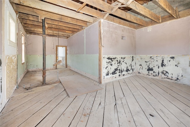 basement with light hardwood / wood-style floors and a wealth of natural light