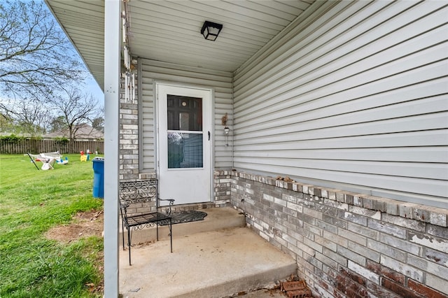 doorway to property with a patio area and a lawn