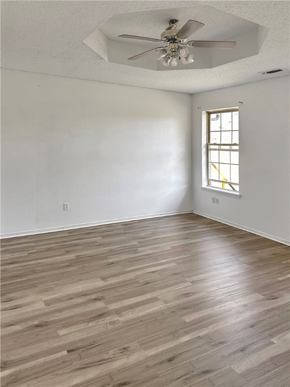 spare room featuring a textured ceiling, ceiling fan, and light hardwood / wood-style flooring