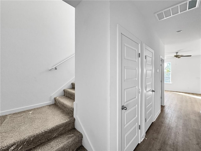 stairway with wood finished floors, baseboards, visible vents, and ceiling fan