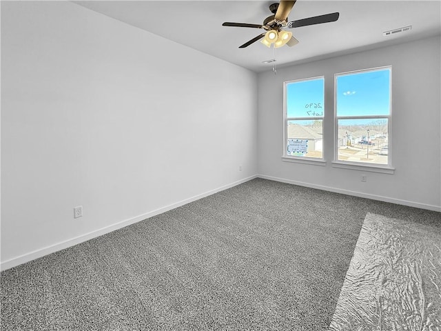 spare room featuring visible vents, carpet floors, baseboards, and ceiling fan