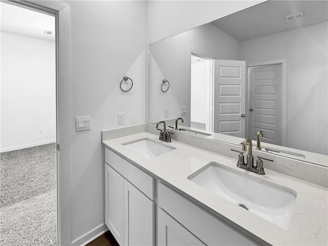 full bathroom featuring double vanity, visible vents, baseboards, and a sink