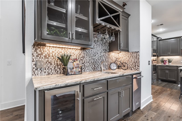 bar featuring sink, wine cooler, dark hardwood / wood-style floors, backsplash, and oven