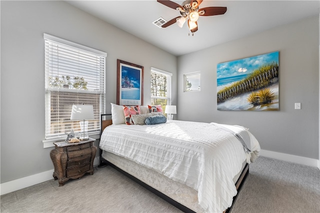 carpeted bedroom with ceiling fan and multiple windows