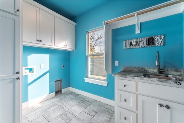 clothes washing area with electric dryer hookup, hookup for a washing machine, sink, and cabinets