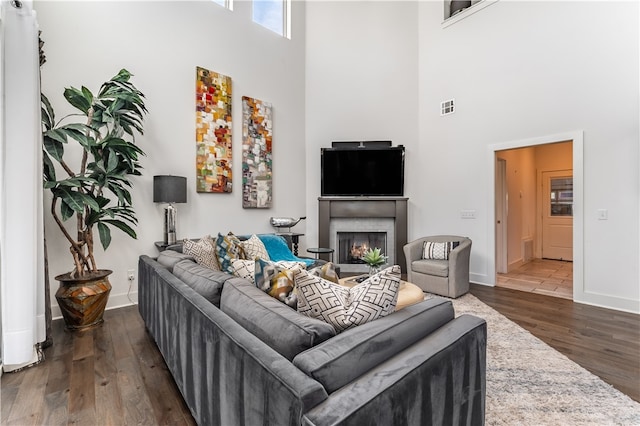 living room featuring dark hardwood / wood-style floors and a high ceiling