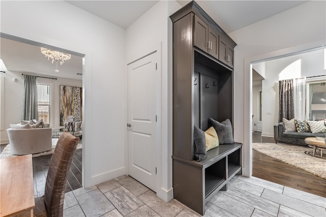 mudroom featuring light wood-type flooring and an inviting chandelier