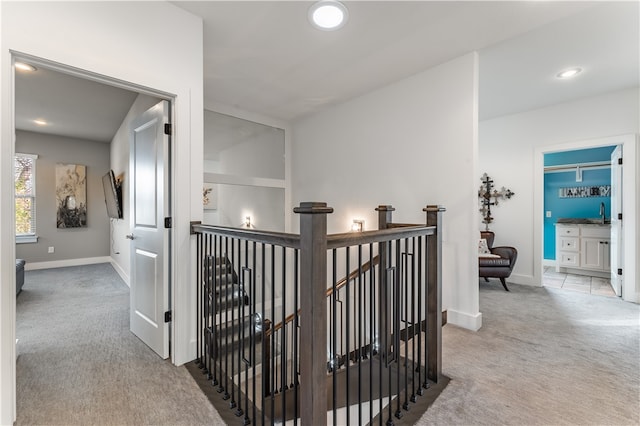 corridor with sink and light carpet