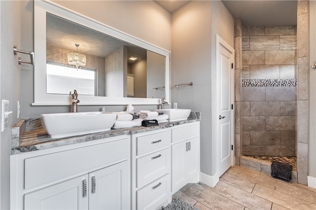 bathroom featuring tiled shower and vanity