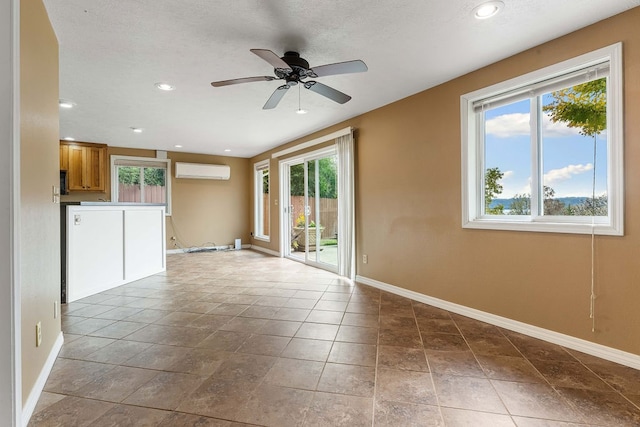 empty room with ceiling fan and a wall mounted air conditioner