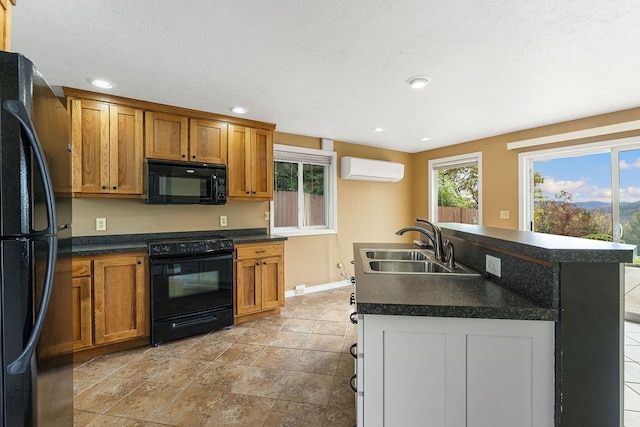 kitchen with black appliances, a center island with sink, sink, a textured ceiling, and a wall mounted AC