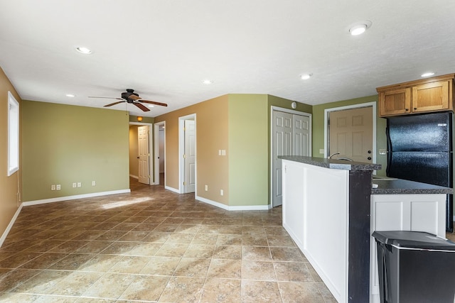 kitchen featuring a center island with sink and ceiling fan